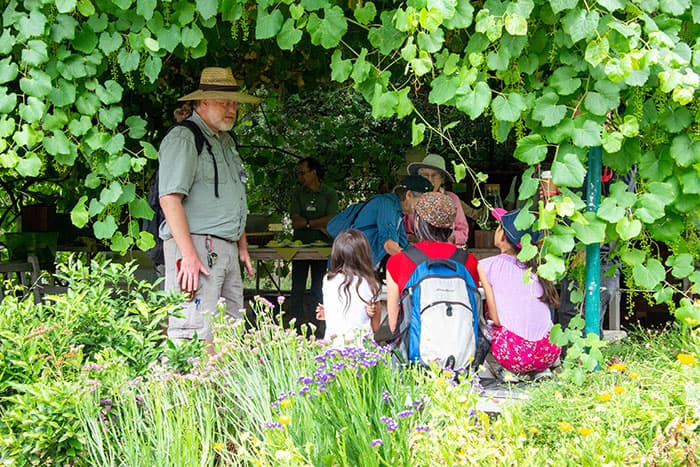 Master gardener volunteer Roger Gray talks with children in the Ranch Garden