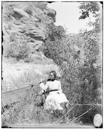 A woman sitting in a chair near a river