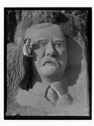 Woman posing with sand carving of Theodore Roosevelt, Santa Monica