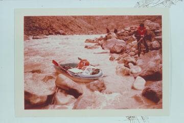 Dock Marston lines a boat at Dark Canyon Rapid.  Jorgen Visbak and Buzz Belknap in distance