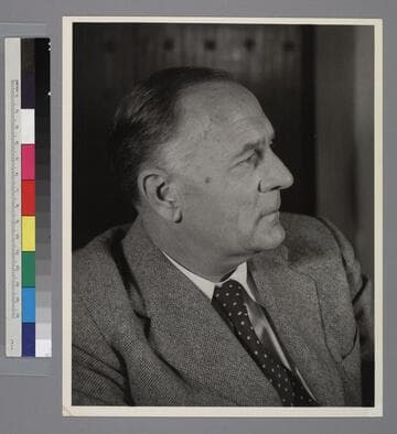 Profile portrait of Edwin Powell Hubble, wearing suit and tie