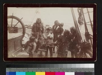 Alaskan natives on ship deck in fur coats