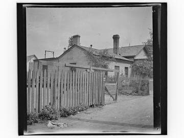 Unidentified brick house with wooden fence