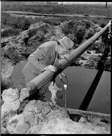 Man inspecting pipe in oil field