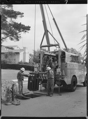 Linemen installing transformer in underground vault