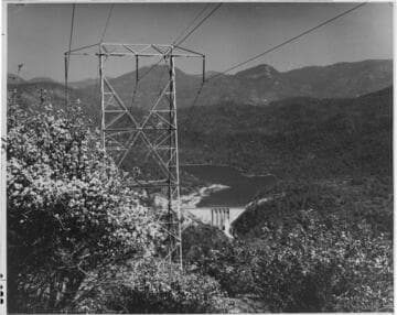 This single-circuit transmission tower stands on a hillside overlooking Dam #7 and Redinger Lake