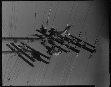 Linemen working on multi-circuit overhead poles