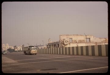 Greyhound bus on Los Angeles Street passing last of the Charles R. Hadley Building
